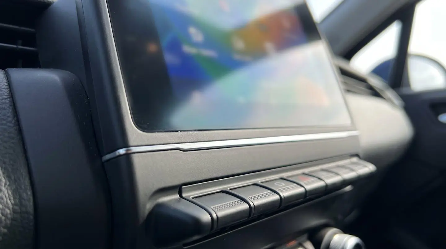 Gros plan de l'écran tactile OpenR Link 9,3 pouces d'une Renault Clio 5 affichant le menu principal avec icônes navigation et multimédia